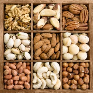 عکس با کیفیت آجیل های خوشمزه و تازه در ظرف اردور خوری چوبی زیبا