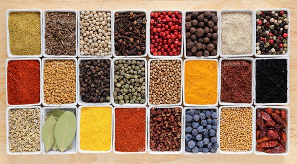 عکس با کیفیت داروهای گیاهی خوش رنگ و ادویه جات مثل زرد چوبه و پودر فلفل قرمز و جوز هندی و برگ بو و فلفل خشک شده داخل ظرف ها و چیده شده در کنار یکدیگر