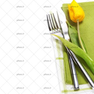 عکس با کیفیت کارد و چنگال در کنار لاله زرد و پارچه سبز و سفید