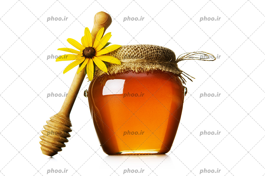 عکس باکیفیت شیشه عسل در کنار قاشق چوبی عسل و گل زرد در بک گراند سفید