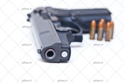 عکس با کیفیت کمری کلت 1911 در کنار چند فشنگ ایستاده در بک گراند سفید