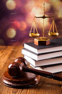 عکس با کیفیت میز چوبی و چکش عدالت در کنار کتاب های قانون و ترازو عدالت بر روی کتاب ها