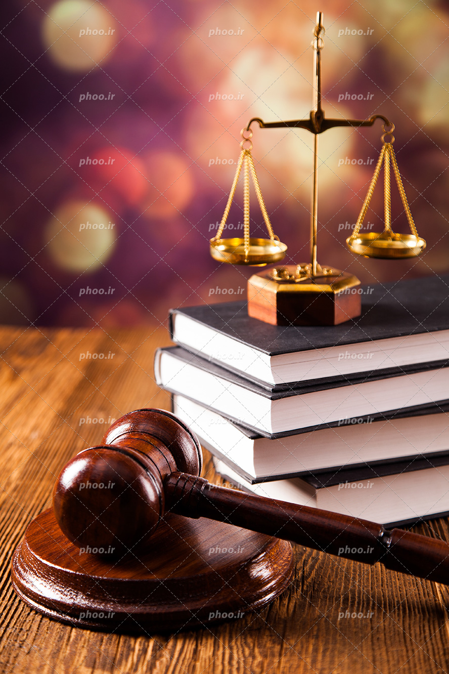 عکس با کیفیت میز چوبی و چکش عدالت در کنار کتاب های قانون و ترازو عدالت بر روی کتاب ها
