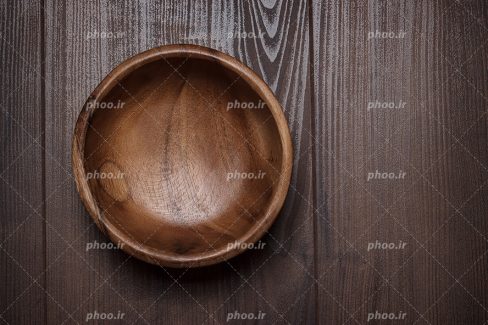 عکس با کیفیت کاسه ی چوبی زیبا قرار گرفته بر روی میز چوبی