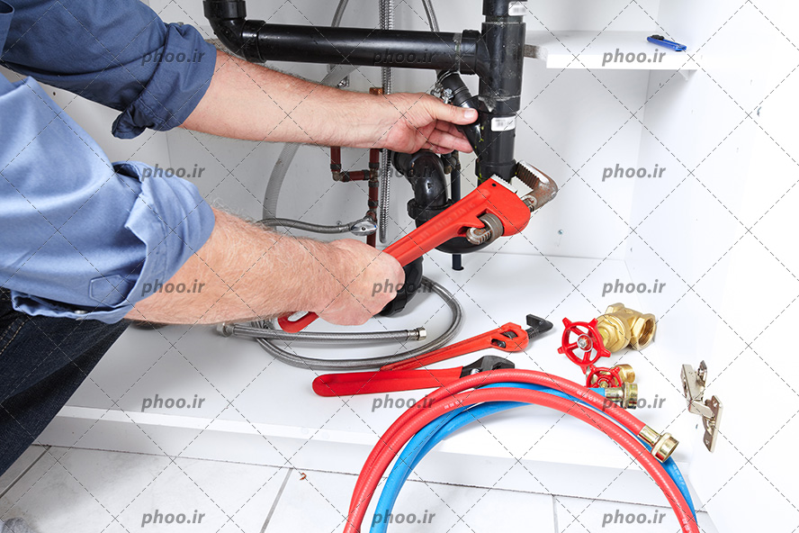 عکس با کیفیت مهندس تاسیسات مکانیکی در حال تعمیرات لوله های آب