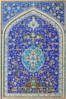 عکس با کیفیت دیوار محراب تزئین شده با خط ها اسلیمی و گل های زیبا و پس زمینه به رنگ آبی لاجوردی