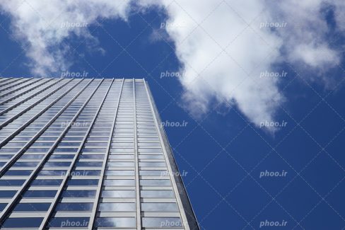 عکس با کیفیت ساختمان مرتفع از نمای پایین و آسمان آبی و ابری