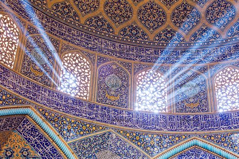 عکس با کیفیت سقف مسجد با طرح های اسلیمی و نوشته های قرآنی و با پنجره های زیبای منبت کاری شده و رد شدن نور از پنجره ها