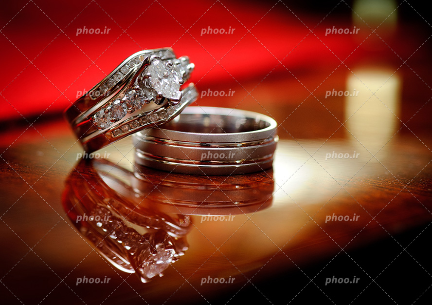 عکس با کیفیت دو انگشتر ست به رنگ نقره ای بر روی میز در کنار یکدیگر