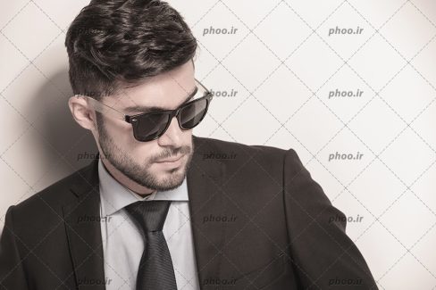 عکس با کیفیت مرد خوشتیپ با عینک دودی و کت مشکی و ته ریش