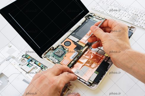 عکس با کیفیت تعمیرکار در حال تعمیر کیبورد مینی لپ تاپ