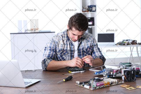 عکس با کیفیت مرد در حال تعمیرات قطعات کامپیوتر به کمک ابزار