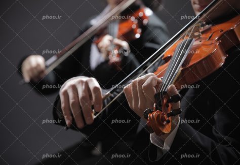 عکس با کیفیت دو مرد ایستاده در حال زدن ویولن