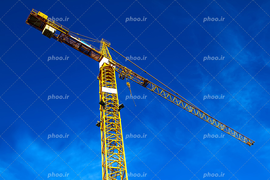 عکس با کیفیت تاور کرین زرد رنگ عظیم از زاویه پایین و آسمان آبی زیبا در تصویر