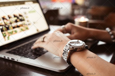 عکس با کیفیت ساعت لوکس در دست زن و زن فریلنسر در حال کار کردن با لپ تاپ و اهمیت دادن به زمان