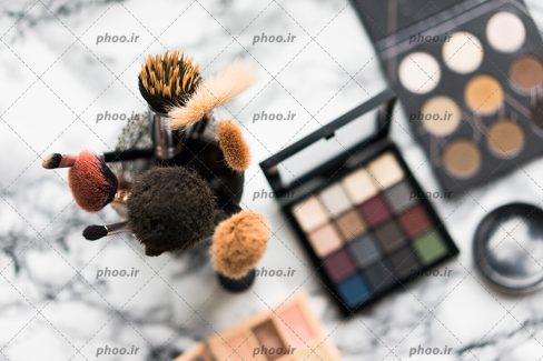 عکس با کیفیت براش با سایز های متفاوت داخل ظرف در کنار یکدیگر و در کنار سایه چشم و رژگونه