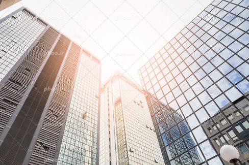 عکس با کیفیت آپارتمان های مرتفع در کنار یکدیگر با شیشه های دو جداره و رفلکس
