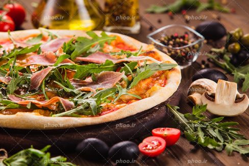 عکس با کیفیت قارچ و سبزیجات و زیتون سیاه در اطراف پیتزای سبزیجات