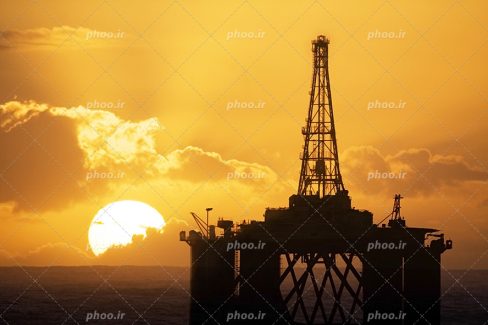 عکس با کیفیت بسیار زیبا دکل حفاری چاه نفتی در آب های دریا و آسمان در حال غروب کردن