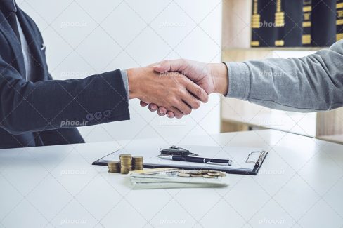 عکس با کیفیت دو مرد در حال دست دادن به دلیل قبول کردن همکاری و امضای قرار داد