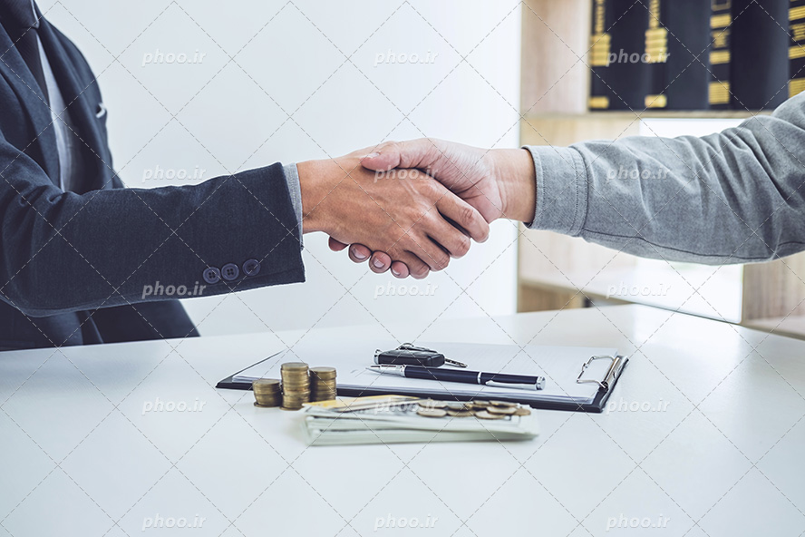 عکس با کیفیت دو مرد در حال دست دادن به دلیل قبول کردن همکاری و امضای قرار داد