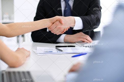 عکس با کیفیت بسیار زیبا زن و مرد در حال دست دادن به یکدیگر به دلیل قبول کردن قرار داد کاری