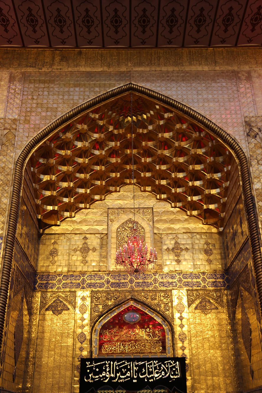 عکس با کیفیت طرح یا پوستر حرم مطهر امام علی (ع) سر در ورودی حرم مطهر امام علی (ع) با لوستر با چراغ های قرمز و بازتاب نور قرمز بر روی دیوار