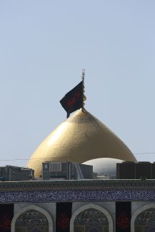 عکس با کیفیت گنبد طلایی امام حسین به همراه پرچم مشکی و پس زمینه آسمان