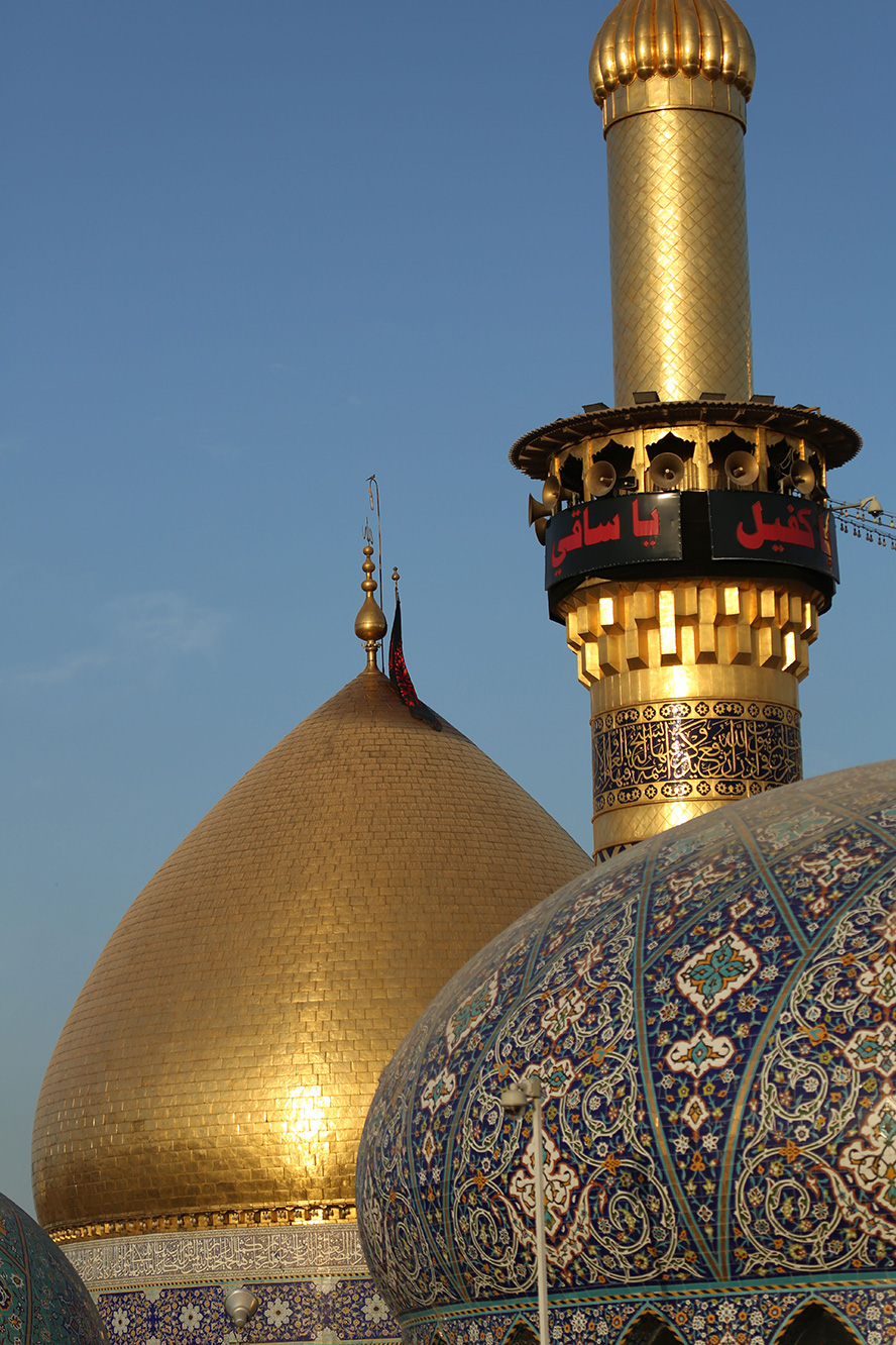 عکس با کیفیت گند و گلدسته طلایی در کنار گنبد تزئین شده با خطوط اسلیمی از نمای نزدیک