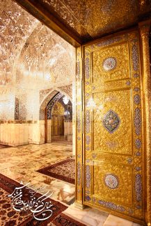 عکس با کیفیت طرح یا پوستر حرم مطهر امام رضا (ع) درب ورودی طلایی حرم و آیینه کاری های زیبای دیوار ها و یک بیت شعر در گوشه تصویر