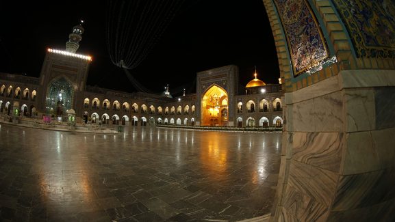 عکس با کیفیت طرح یا پوستر حرم مطهر امام رضا (ع) گلدسته ساعت در روب ه رو و در سمت راست گنبد زیبا طلای حرم امام رضا