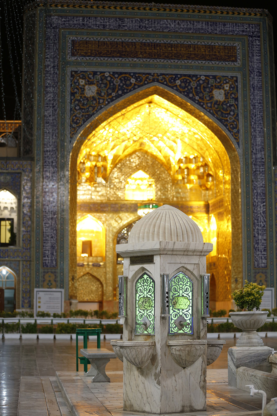 عکس با کیفیت طرح یا پوستر حرم مطهر امام رضا (ع) سقا خانه کوچک زیبا سنگ سفید و نور سبز در آن در مقابل دیوار طلایی