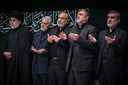 عکس با کیفیت تصویر شهید سردار قاسم سلیمانی عزاداران حسینی و شهید سردار سلیمانی در بین آنها و در کنار مقتدی صدر در حال دعا کردن