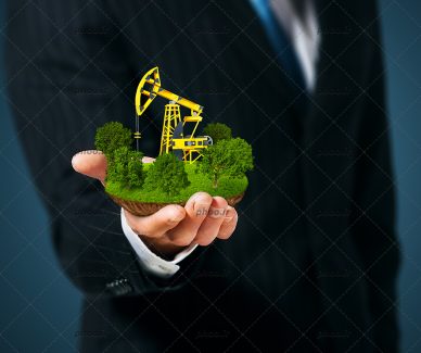 عکس با کیفیت درختان سرسبز به دور ماشین آلات ساختمان و قرار گرفته در دست مرد با کت و شلوار مشکی