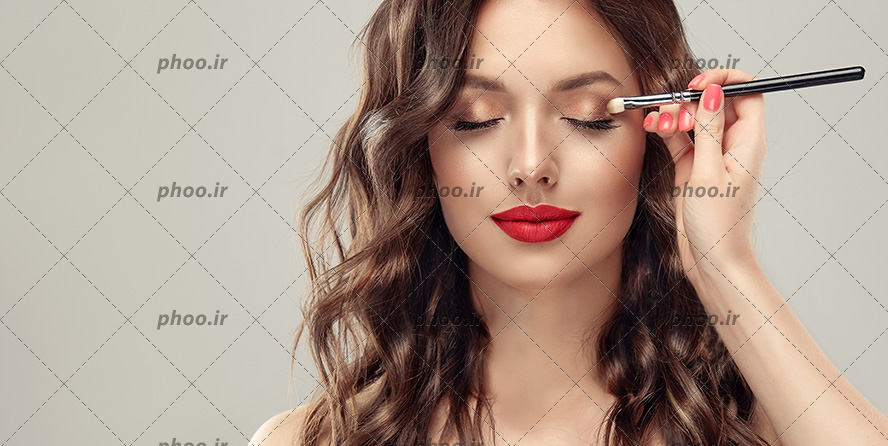 عکس با کیفیت آرایشگر در حال آرایش کردن چشم زن زیبا