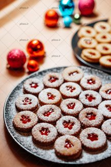 عکس با کیفیت شیرینی های خشک تزئین شده با ژله در ظرف و توپ های رنگارنگ برای تزئین درخت کریسمس