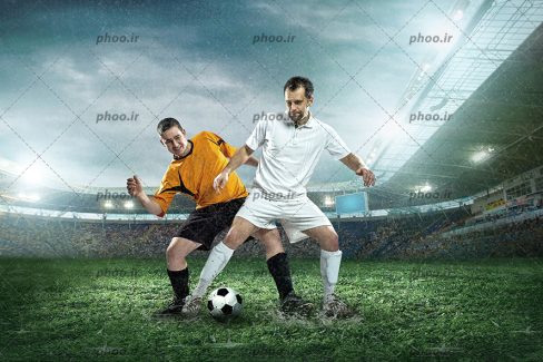 عکس با کیفیت دو فوتبالیست با لباس های سفید و نارنجی در حال گرفتن توپ از یکدیگر در زمین چمن