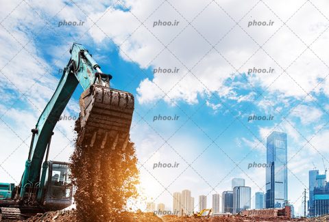 عکس با کیفیت در حال خاکبرداری با ماشین بزرگ مخصوص و برج های مرتفع در کنارش