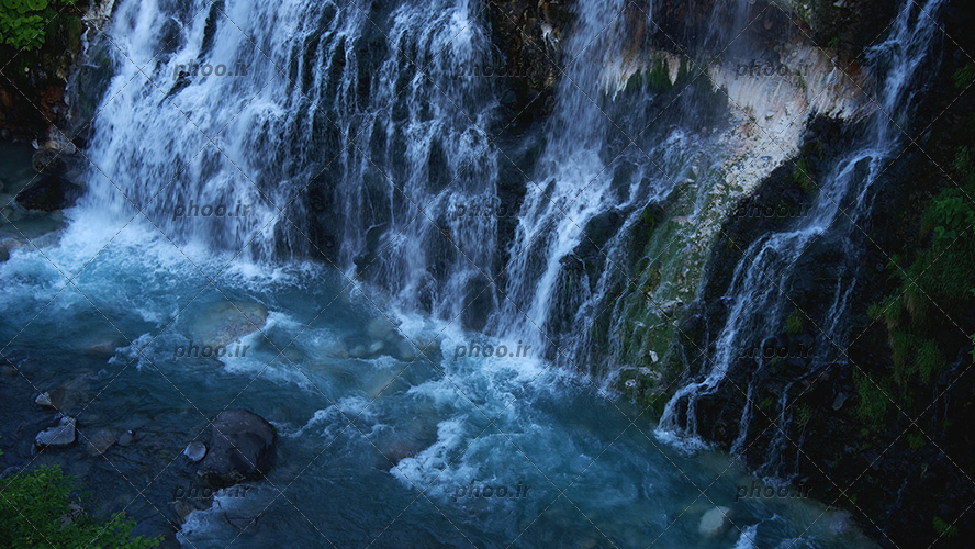 عکس با کیفیت آبشار بسیار زیبا جاری از صخره ها و تخته سنگ ها