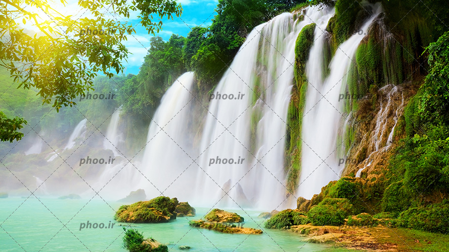 عکس با کیفیت آبشار زیبای افقی در دل صخره ها و دریاچه زیبا در پایین آبشار