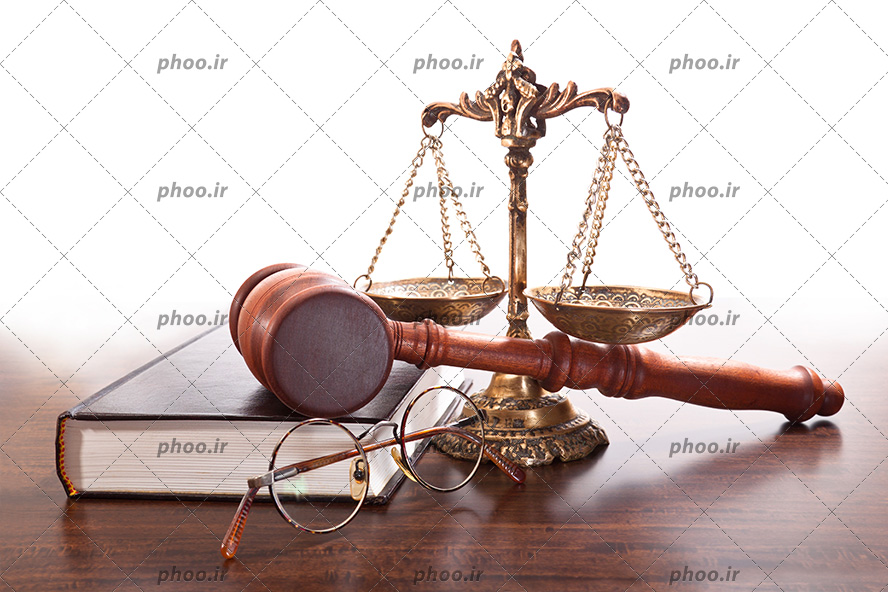 عکس با کیفیت چکش عدالت و کتاب عدالت و ترازو عدالت و عینک در کنار یکدیگر بر روی میز چوبی
