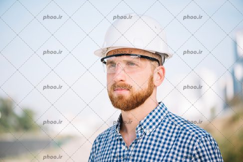 عکس با کیفیت مهندس ساختمان با عینک و کلاه ایمنی سفید