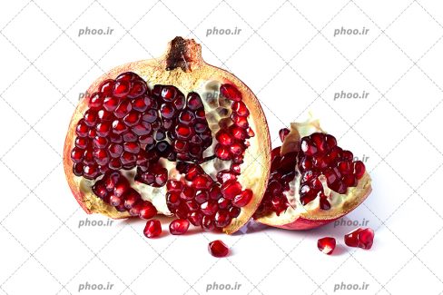 عکس با کیفیت پس زمینه سفید و انار اسلایس شده در آن و دانه های یاقوتی انار در کنار آن
