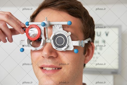 عکس با کیفیت عینک های اپتومتری بر روی چشمان مرد در حال تشخیص شماره چشمانش