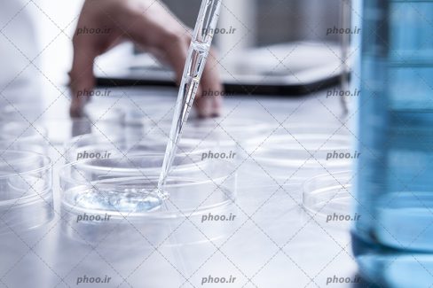 عکس با کیفیت پزشک آزمایشگاه در حال آزمایش در شیشه های آزمایشگاهی