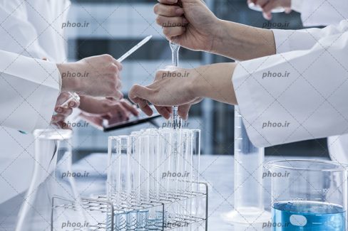 عکس با کیفیت پزشک زن و مرد در حال آزمایش و استفاده از شیشه آلات آزمایشگاهی