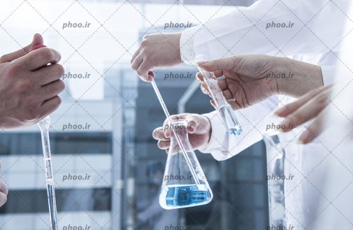 عکس با کیفیت شیشه آلات آزمایشگاهی در دست پزشک آزمایشگاه
