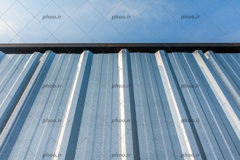 عکس با کیفیت سقف شیبدار فلزی و آسمان آبی در بکگراند