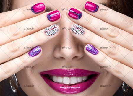 عکس با کیفیت رژ صورتی زیبا بر روی لب های زن و ناخن های لاک زده به رنگ صورتی در مقابل چشم ها