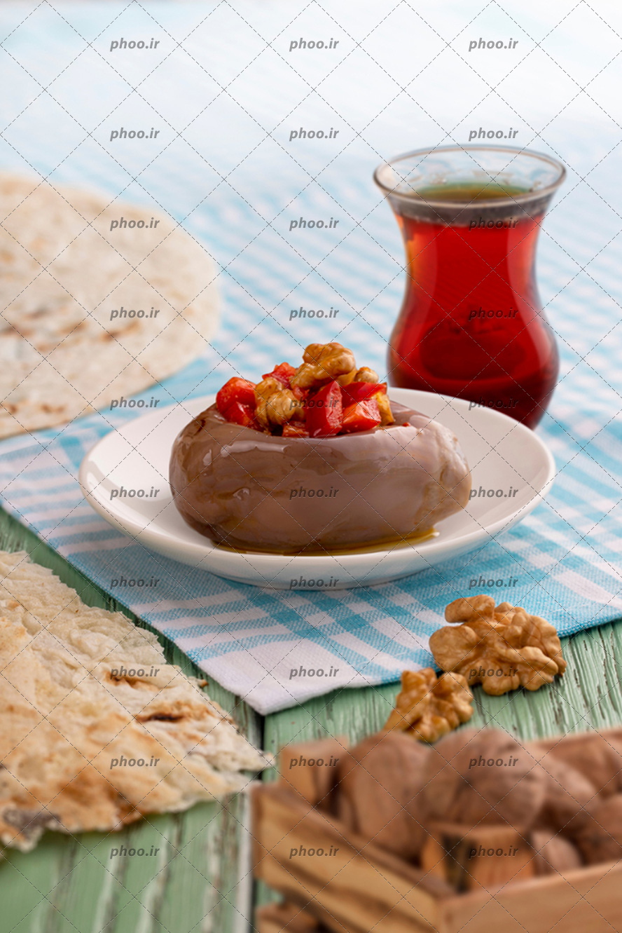 عکس با کیفیت کیک شکلاتی در کنار چای خوش رنگ و چند گردو در کنارش